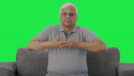 Relaxed-Indian-old-man-doing-breathe-in-breathe-out-exercise-Green-screen