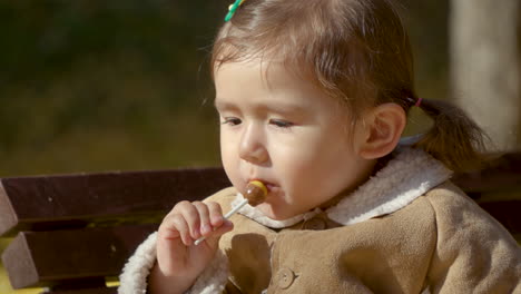 little girl sucking happy lollipop in slow motion