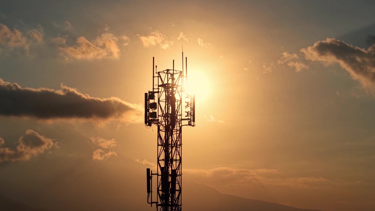 Silhouette di una torre di rete mobile al tramonto con nuvole suggestive. Filmato concettuale su telecomunicazioni, tecnologia wireless e connettività.
