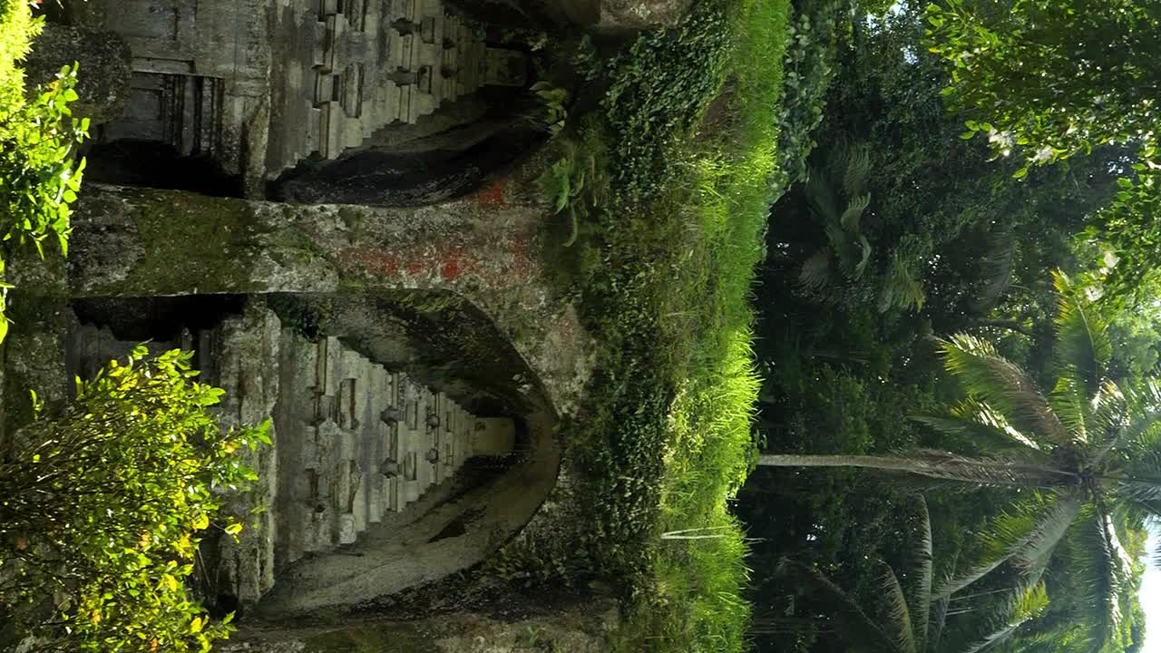 toma de las ruinas históricas de un templo en bali, indonesia, con una fuente y una vista de la densa selva