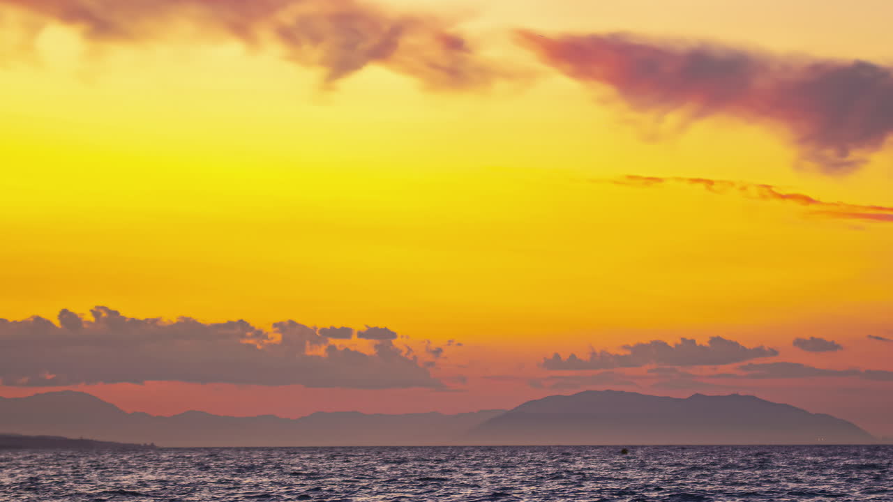 스페인 말라가에서, 매혹적인 타임 프는 웅장한 산과 구름과 황색 빛의 반사와 함께 놀라운 해양 풍경을 묘사합니다.