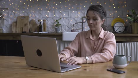 mujer trabajando en una computadora portátil en una cocina