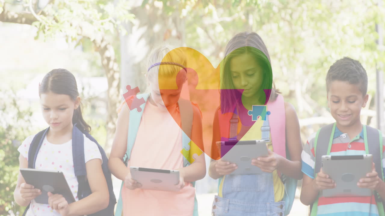 animación de coloridas piezas de rompecabezas corazón sobre niños de escuela usando tabletas