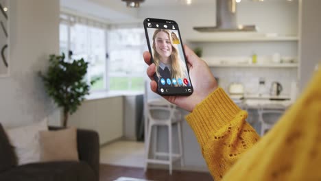 mujer teniendo una reunión de video en su teléfono inteligente en casa