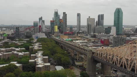 drone aerial slide back along the queensboro bridge in nyc moving towards queens