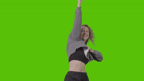 studio shot of young woman having fun dancing against green screen 20