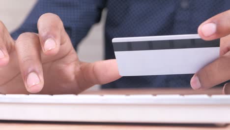 person using credit card on a keyboard