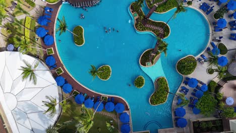 las imágenes de drones capturan una vibrante piscina turística en phuket, tailandia, mostrando su diseño único y sus alrededores tropicales.