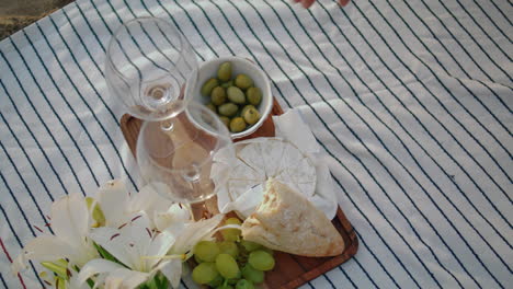 woman hands taking olive at beach picnic closeup. unknown girl eating at nature