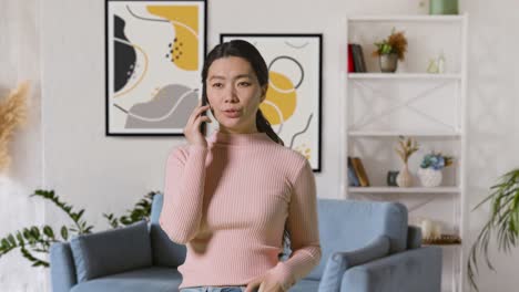 Woman-Indoors-At-Home-In-Lounge-Talking-On-Mobile-Phone