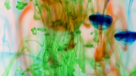 slow motion abstract footage of colored ink droplets combining in liquid