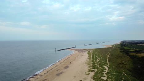 Amplia-Toma-Aérea-Del-Paisaje-Volando-Sobre-Una-Playa-Británica-Vacía-En-Norfolk