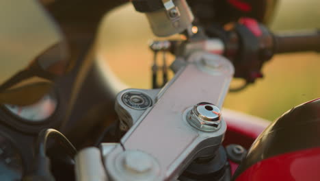 a close-up of a person s hand as they insert a key into the ignition of a motorcycle