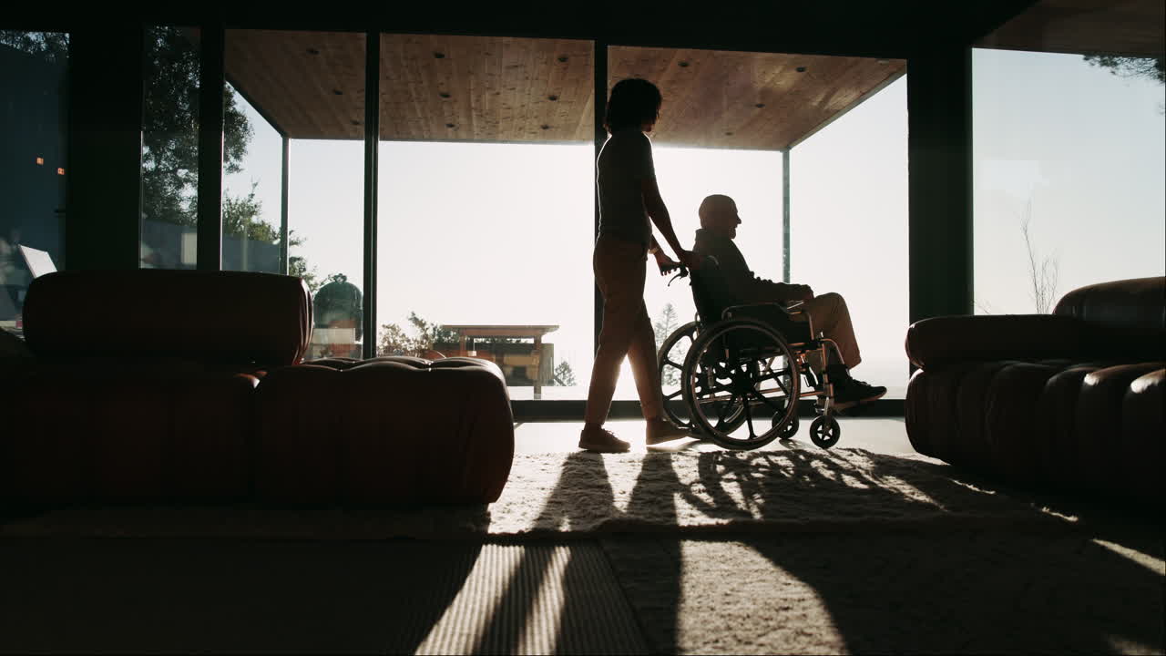 Elderly man in wheelchair with caregiver