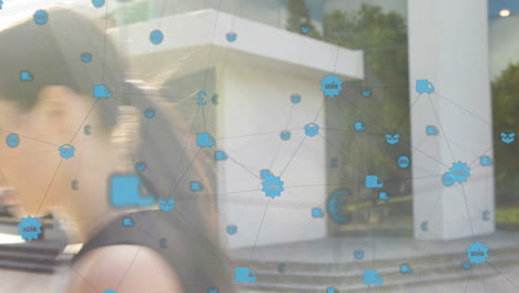 animación de una red de iconos digitales sobre una mujer de negocios caucásica que usa un teléfono inteligente al aire libre