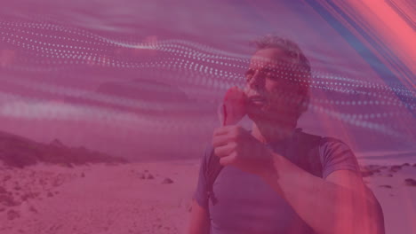 Man holding red flower standing on sandy beach, showcasing tech theme with dotted wave overlays