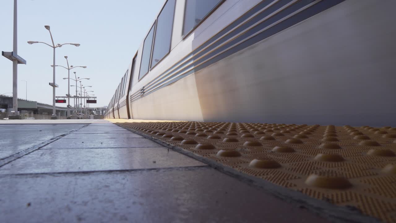 도심의 번잡한 지역에 있는 대중 교통 환승역까지 끌어당기는 기차의 낮은 클로즈업 샷