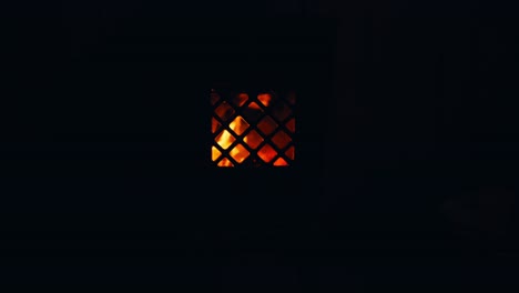 a fire flickers behind the grate of an old wood stove at reinsjøen in åfjord, trøndelag, norway - close up