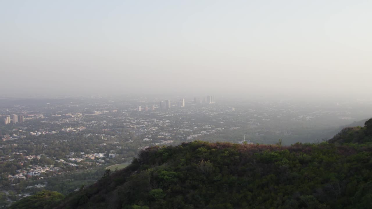 Evening aerial of Islamabad with city skyline and sunset behind Margalla Hills. Islamabad, Pakistan