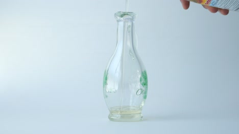 pouring olive oil into a glass bottle