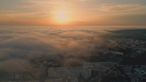 golden sunset illuminating cloudy town at evening. aerial sun over light clouds