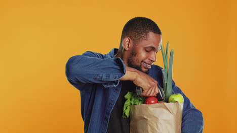 joven afroamericano escaneando todos los productos ecológicos en el estudio