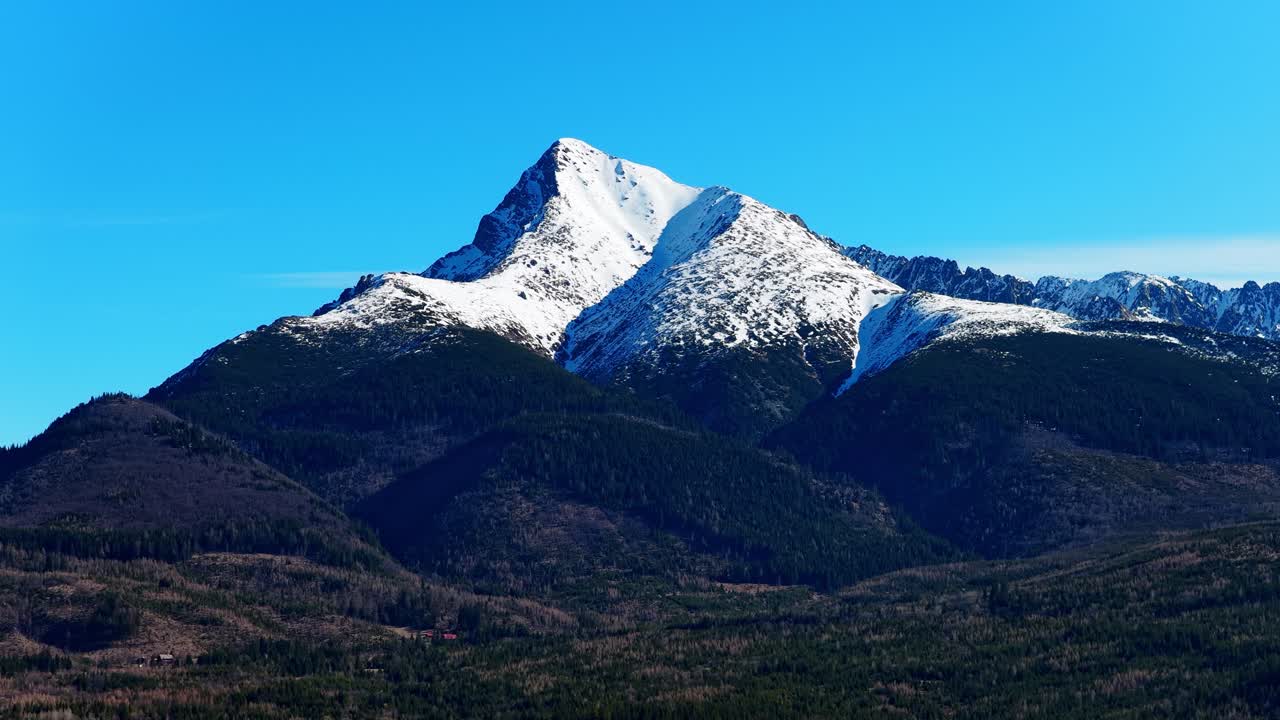 Cận cảnh đỉnh Kriváň nổi tiếng ở High Tatras, Slovakia. Dãy núi phủ tuyết phía trên cảnh quan rừng dưới bầu trời xanh trong. Biểu tượng đặc trưng của Slovakia, lý tưởng cho các chủ đề du lịch và thiên nhiên