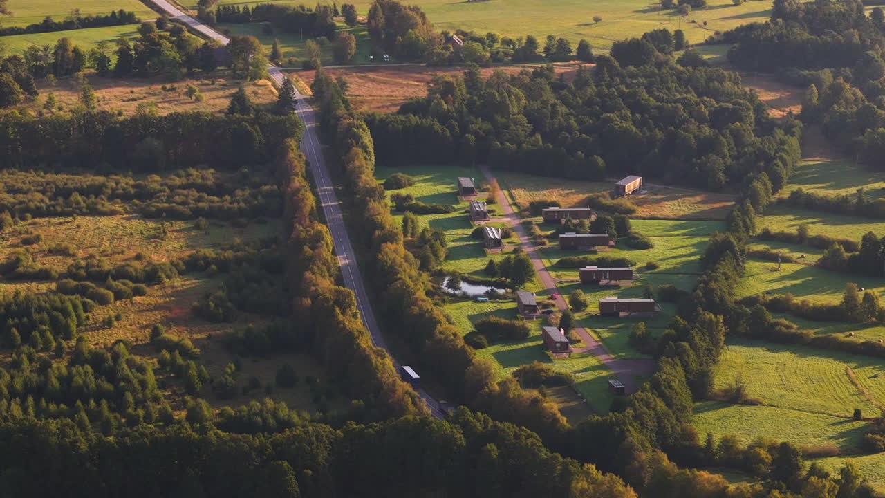 Aerial zoom in on traffic on road in Strante Ulmale region during golden hour, Latvia