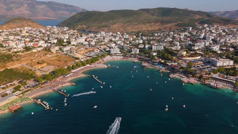 ksamil, albania with tourists enjoying the beach and clear turquoise waters, aerial view