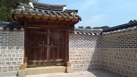 Wooden gate in stone wall at Hongyureung royal tombs in Guemgok South Korea.
