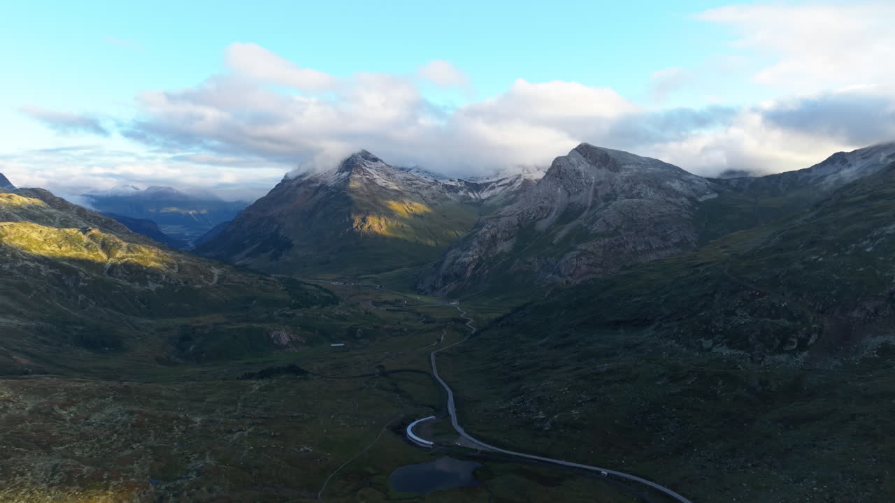 Scenic view of the Swiss Alps at sunrise with rolling hills and clouds