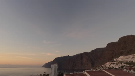 timelapse de la puesta de sol de los acantilados de los gigantes en tenerife con nubes rayadas que se desarrollan sobre la ciudad