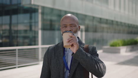 portrait of senior african american businessman ceo relaxed drinking coffee enjoying urban outdoors on lunch break in city