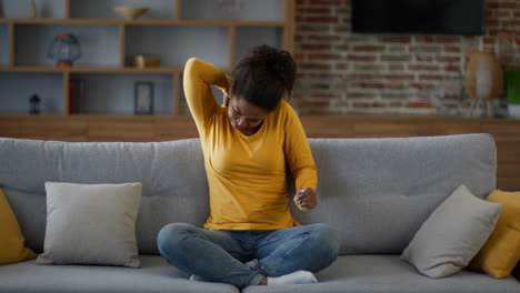 woman experiencing neck pain on couch
