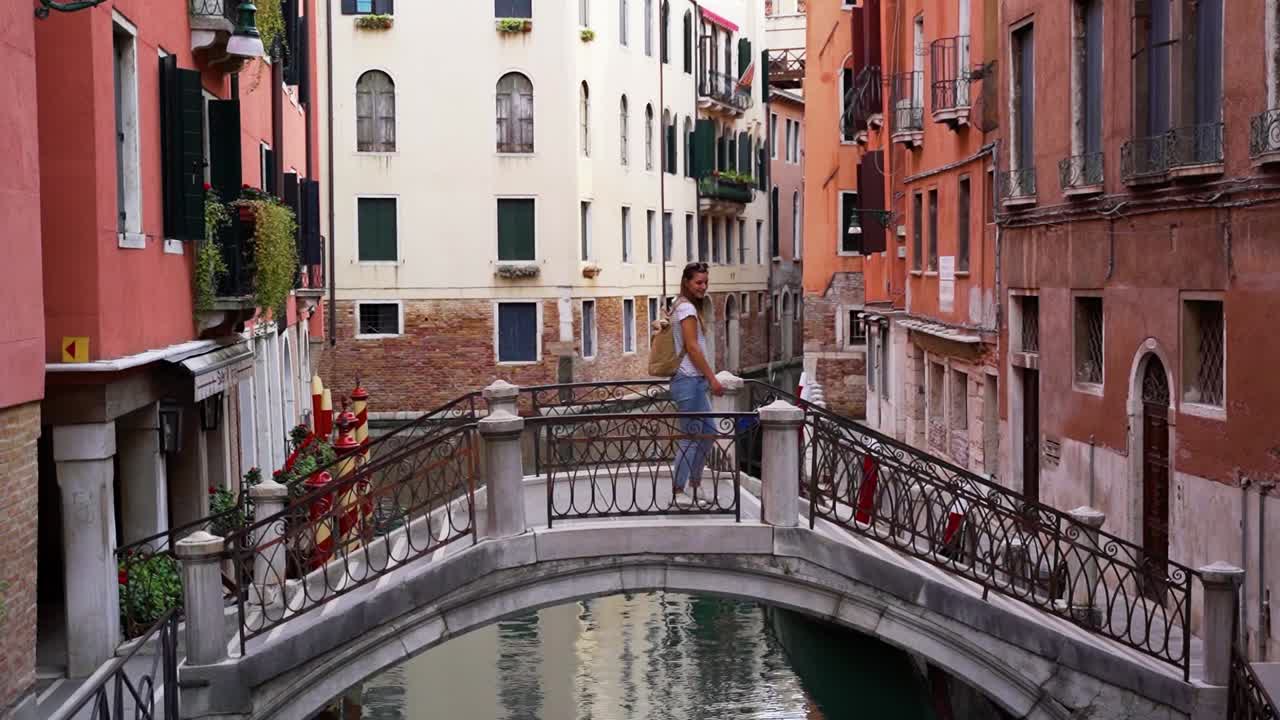uno de los cientos de puentes en venecia cruzados por una mujer