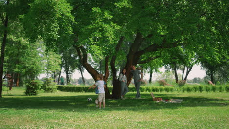 niños ágiles jugando juegos activos en la naturaleza. familia feliz disfrutando de un picnic alegre.