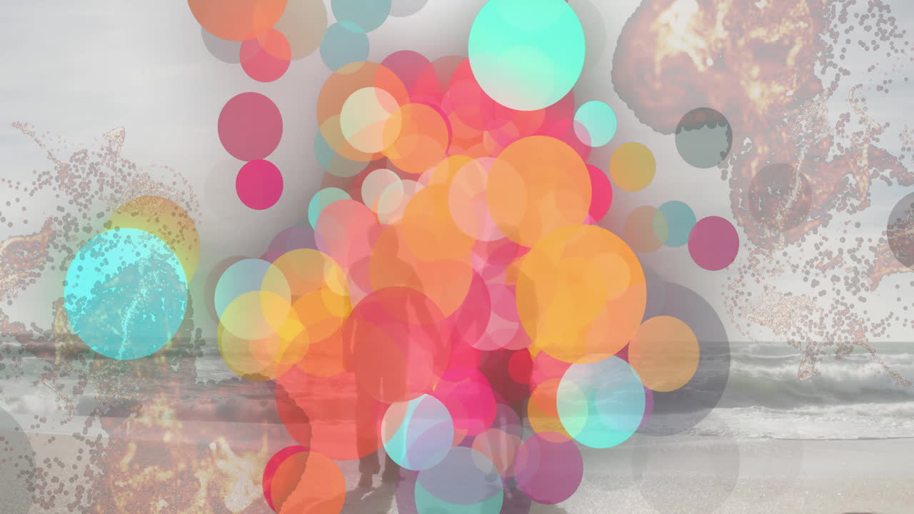 Animation of colorful circles overlaying silhouettes of people walking on beach