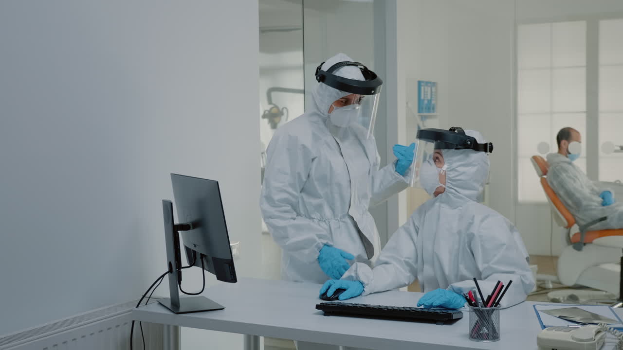 стоматологическая команда стоматологов за столом использует компьютер для ухода за зубами в стоматологическом кабинете