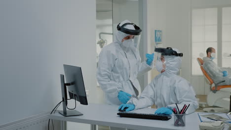 equipo de estomatología de dentistas en el escritorio usando computadora para el cuidado dental en el gabinete dental
