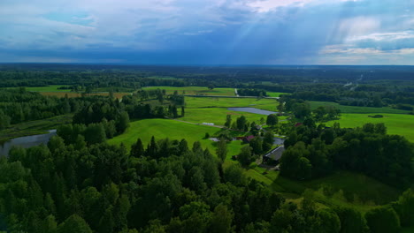 slow motion drone view ,green pastures, rain and clouds in distance, god rays