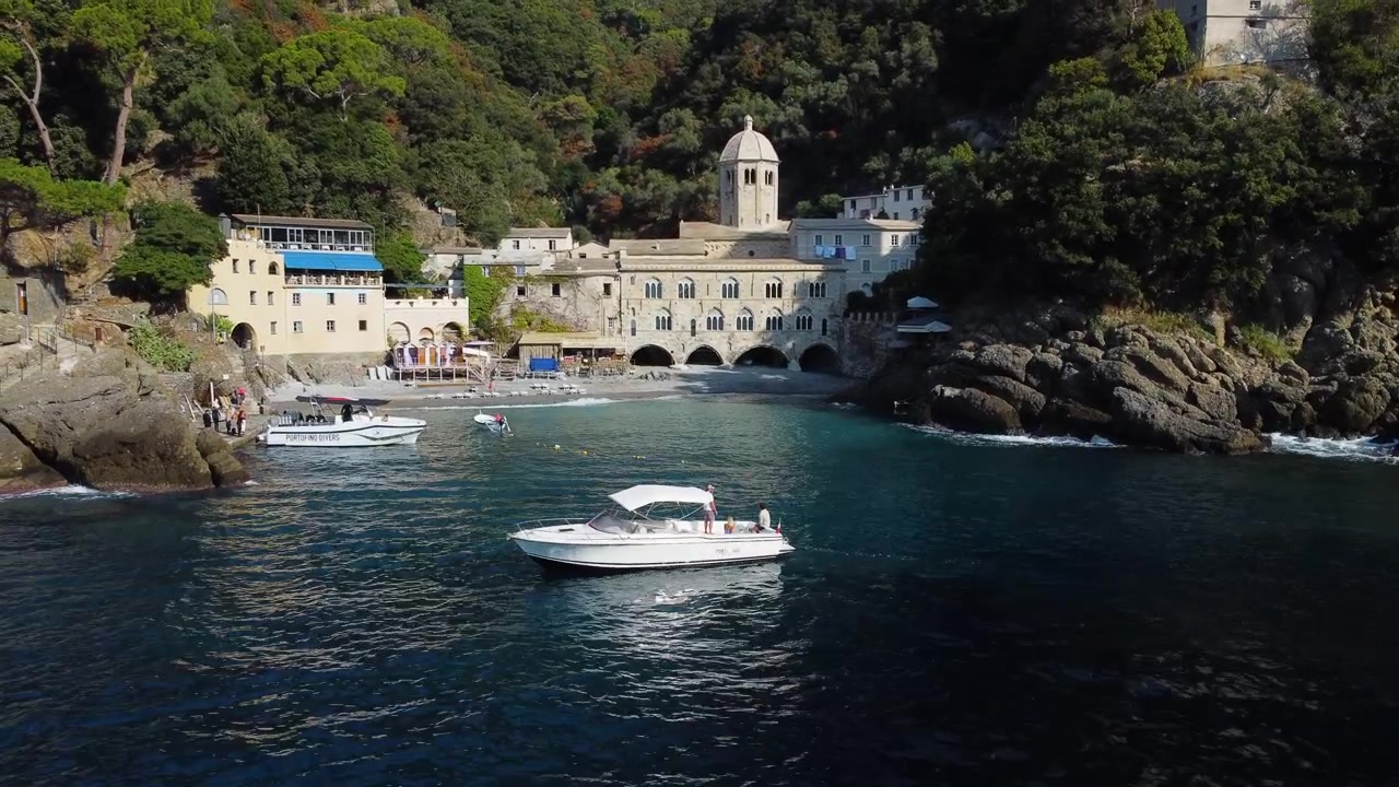 Vista aerea di uno yacht di fronte all'abbazia di San Fruttuoso, nella soleggiata Liguria, Italia