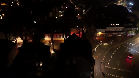 aerial tracking shot of car on road at night. historic small town with lighting lantern after rain. housing area and neighborhoods in american town, usa. top down flyover.