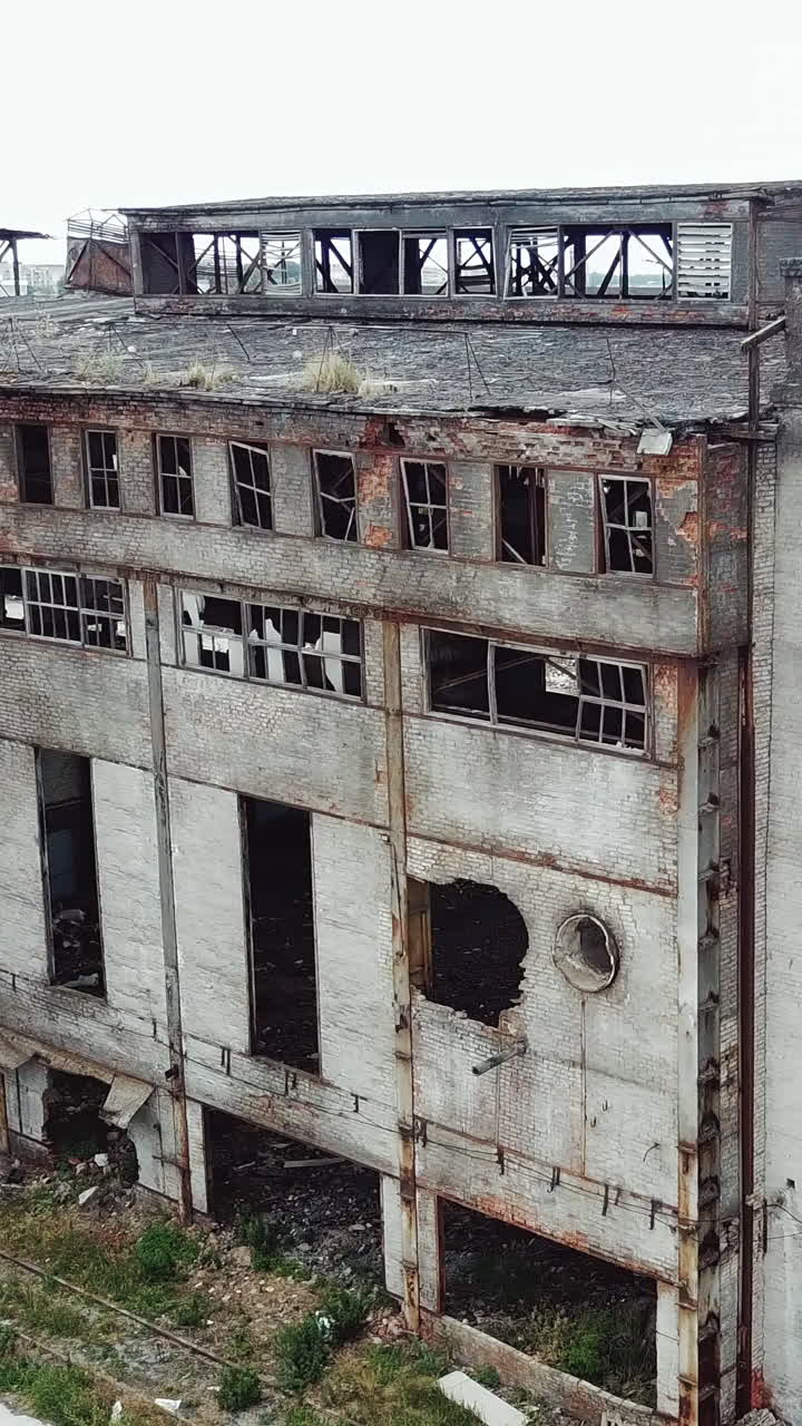 Aerial view from the air to an abandoned factory. Old industrial building for demolition.. Vertical video