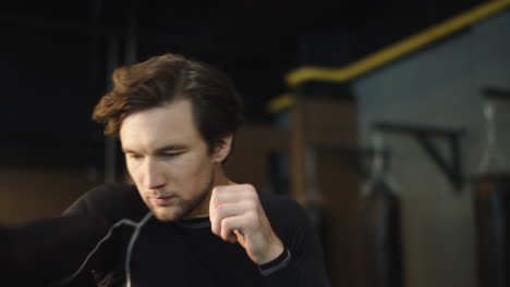 angry male boxer practicing beats in sport club. male athlete training at gym