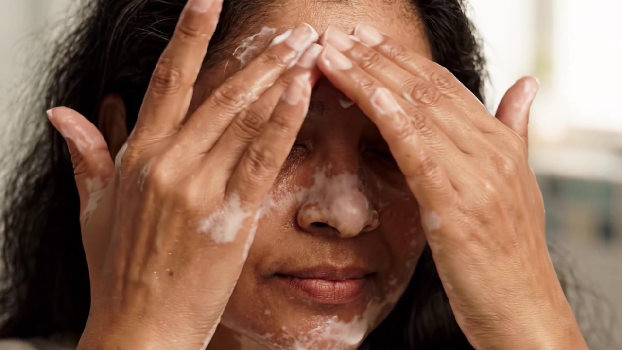 Woman Applying Foaming Cleanser on Her Face, Demonstrating a Skincare Routine for Healthy, Glowing Skin and Self-Care Practices at Home