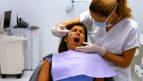 Dentist-injecting-female-patient-in-mouth