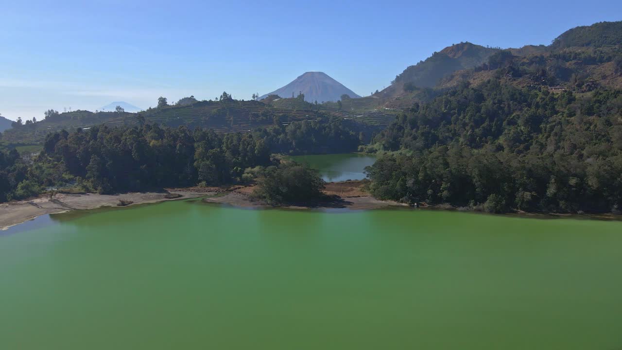 Aerial view of Dieng's Telaga Warna, the color-changing lake with forests in Java, Indonesia