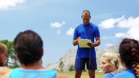 Male-trainer-training-people-in-boot-camp-4k