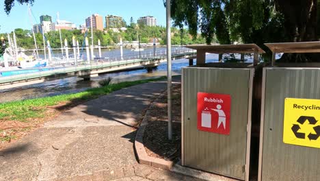 sequence of recycling and trash bins outdoors.