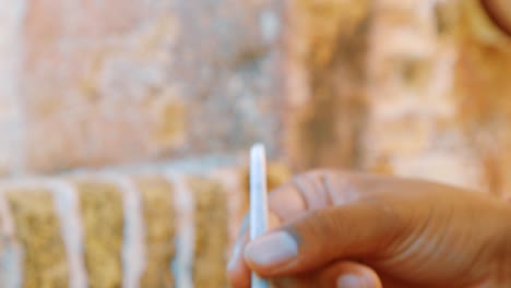 Slow-motion-shot-of-hands-carefully-rolling-a-cannabis-joint-outside-in-the-Caribbean